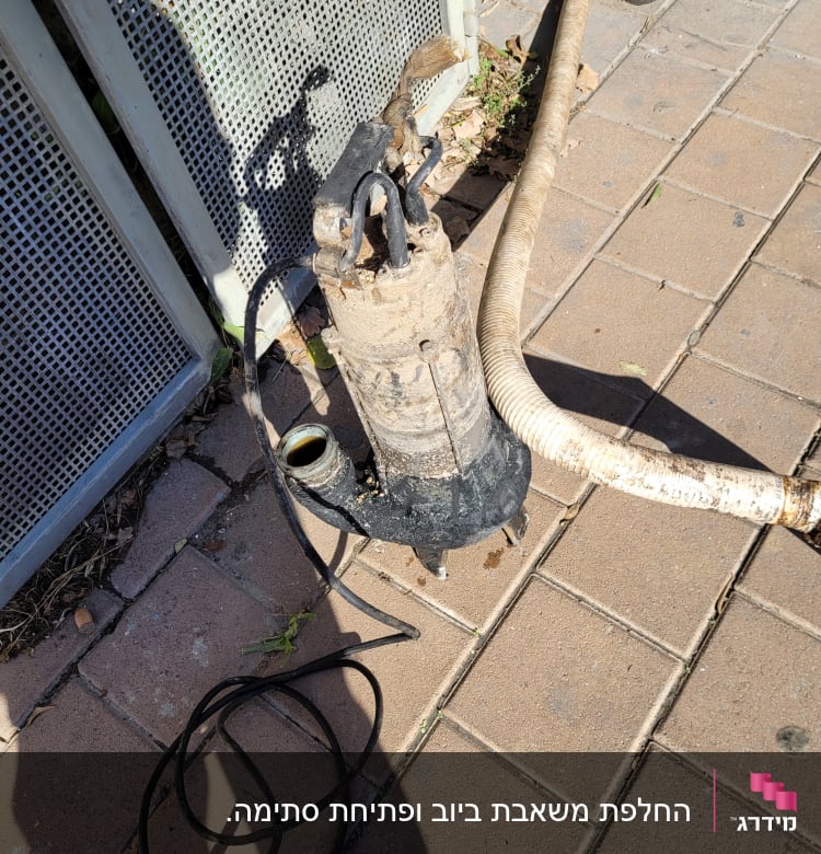 משאבה עם צינור על מדרכה